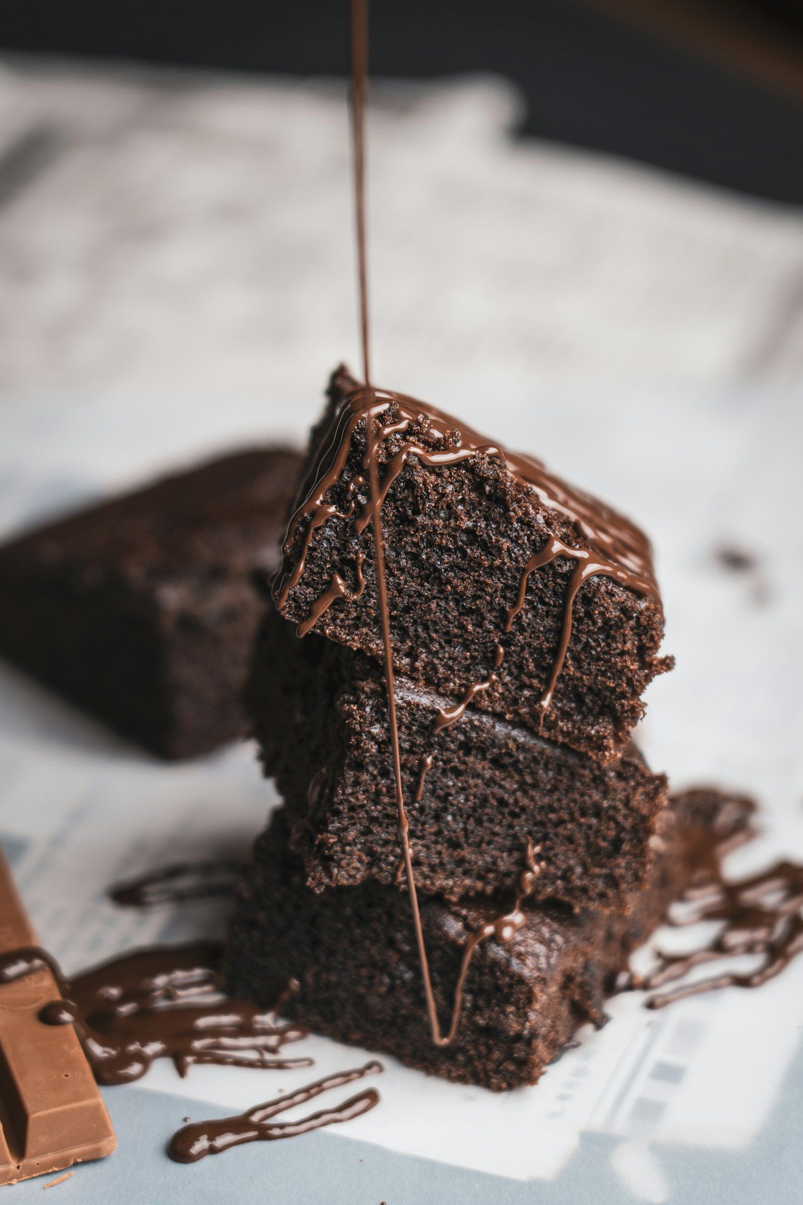 A dark chocolate cake with a glossy crackled top, sprinkled with flaky salt and dusted with powdered sugar.