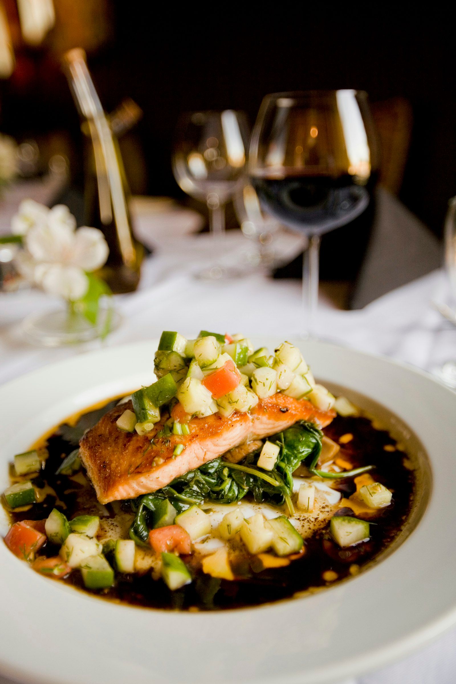 A fillet of salmon with a deeply caramelized miso glaze, plated over white coconut rice and scattered with sesame and scallion.
